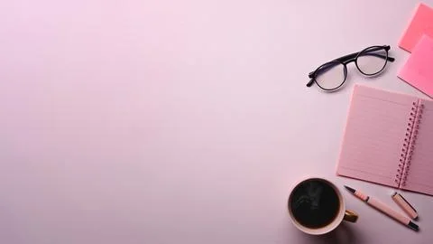 Above view coffee cup, notebook, sticky notes and glasses on pink background. 스톡 사진