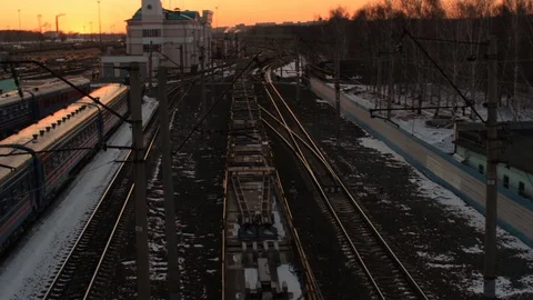 Above view of freight train with flatcars passing by railway station at sunset Stock Footage 75364461