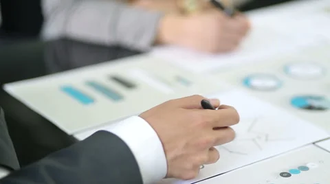 Above view  graphic data templates on table with unrecognizable business people Stock Footage 54589130