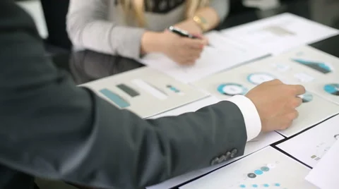 Above view  graphic data templates on table with unrecognizable business people Stock Footage 54589208