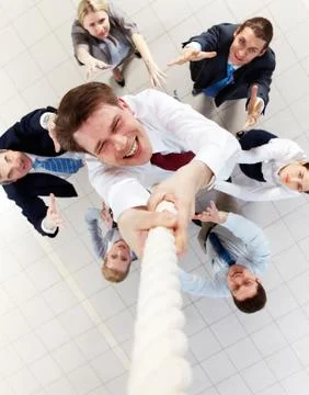 Above view of happy employer ascending up the rope with several employees beneat Stock Photos