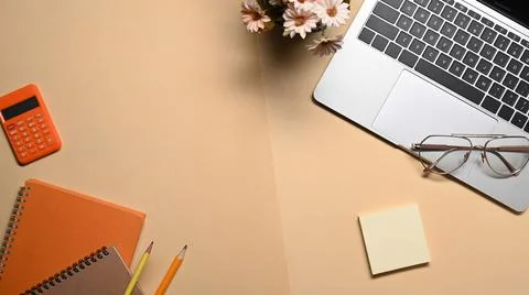 Above view laptop computer, notebook, glasses and calculator on beige background 스톡 사진