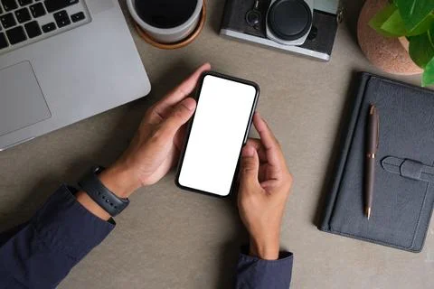 Above view of man using mobile phone at creative workspace. Blank screen fo.. Stock Photos