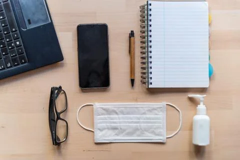 Above view of remote work kit on wooden office desk with hand sanitizer and f Stock Photos