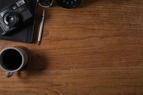 From above view of retro camera, coffee and notebook on wooden table. Top v.. Foto stock