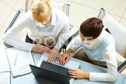 Above view of two businesswomen typing on a laptop Stock Photos