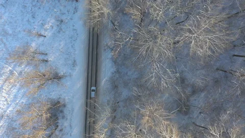Above view of white SUV going on a snow covered forest road. Car rides at winter Stock-Footage 252569294