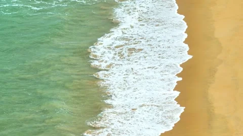 From above, the waves break gently on the beach. Stock Footage 307939990