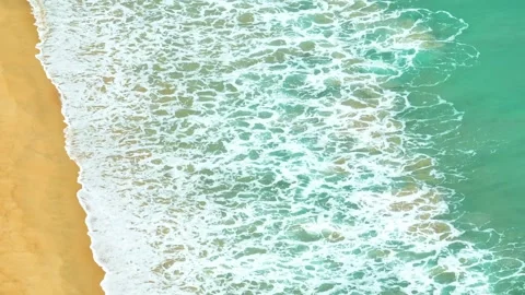 From above, the waves break gently on the beach. Video stock 307940036