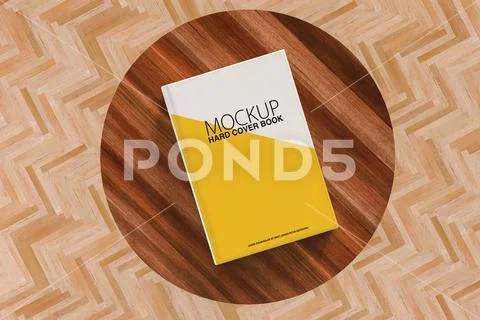 From above of white mock up book placed on round wooden table in light living  Plantilla PSD