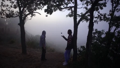 From above young slim man throwing up hacky sack standing under trees on hill Stock Footage 81203347