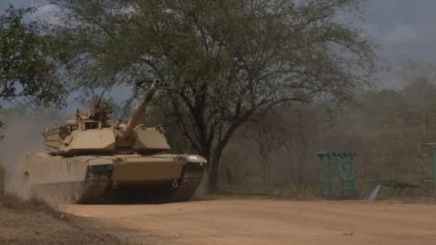 Abrams battle tank tracking at speed through Camp Ban Chan Krem, Thailand Stock Footage 104601797
