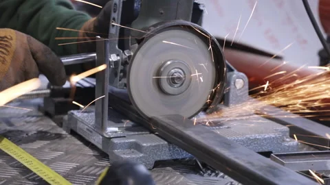 Abrasive disc of powerful angle grinder cuts metal beam Stock Footage 193910894