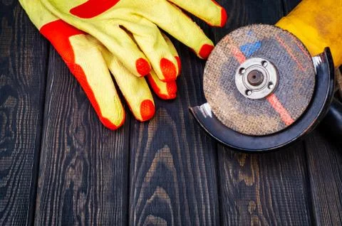 Abrasive tool and builder protection on dark vintage wood background. Stock Photos