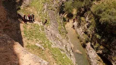 Abseiling into a Canyon -seen from above Stock Footage 98403881