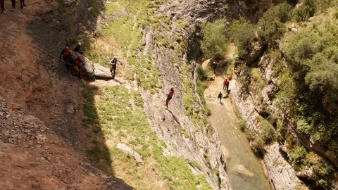 Abseiling a man into a Canyon Stock Footage 98238805