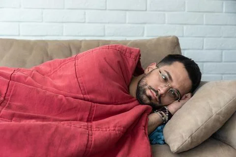 Absolute solitude. Side view of a depressed unhappy sad man lying on the so.. Stock Photos