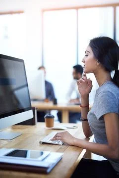 Absorbed in her work tasks. a focused young businesswoman using a computer at Foto stock