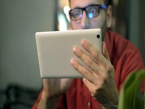 Absorbed sitting in the cafe and browsing internet on tablet, steadycam shot Stock Footage 75907802