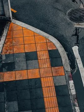 Abstract Aerial Pattern of Orange Tactile Paving Arrow Design on Grey Sidewal 스톡 사진