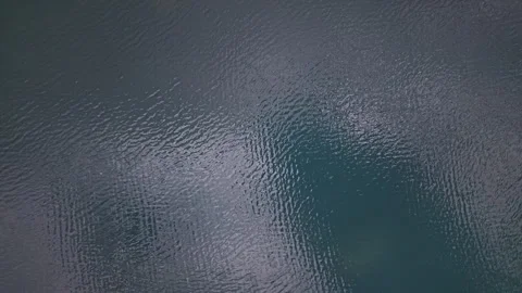 An abstract aerial view captures the dark blue, choppy texture of a water Stock Footage 345566375