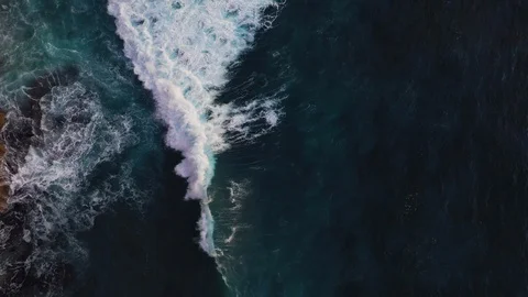 Abstract aerial view of ocean waves crashing on rocky shoreline Stock Footage 109168472