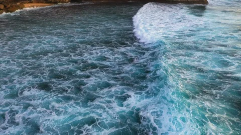 Abstract aerial view of ocean waves crashing on rocky shoreline Video stock 109955044