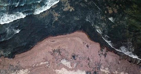 Abstract Aerial View Of Ocean Waves Crashing On Rocky Coastline Video stock 227257921