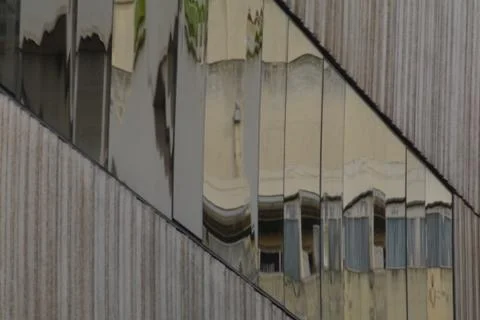 Abstract and artistic reflections in a window of a concrete building Foto stock