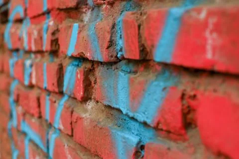 Abstract and texture of a red brick wall painted red with some graffiti Foto stock