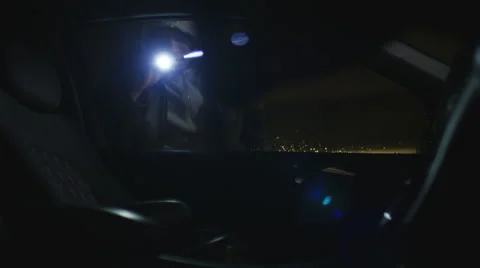Abstract angle of thief looking into a locked car for valuables at night Stock Footage 68086774