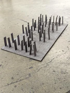Abstract Architectural Model Featuring Vertical Pillars on Textured Base 库存照片