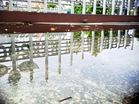 Abstract architectural reflection in water on a paved surface creating a un.. Stock Photos