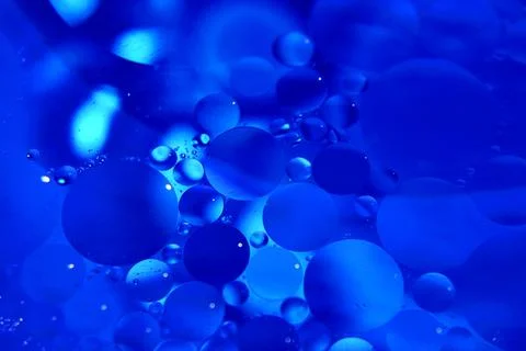 Abstract background with blue bubbles of oil in water. Macro photography. Vie Stock Photos
