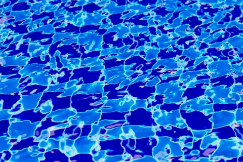 Abstract background from blue tiled pool with clear rippling water Stock Photos