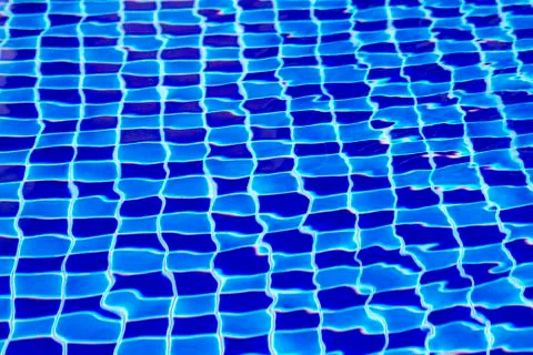Abstract background from blue tiled pool with clear rippling water Stock Photos