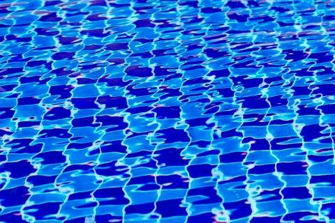 Abstract background from blue tiled pool with clear rippling water Stock Photos