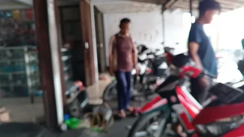 Abstract background blur of a busy motorcycle repair shop with vehicles. Stock Footage 318599364