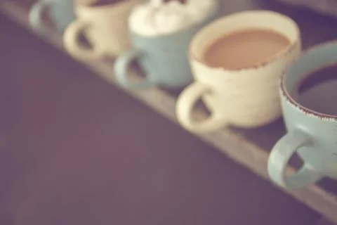 Abstract background. Blur. Row of coffee cups with fresh coffee on a wooden Stock Photos