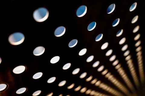 Abstract background of blurry dot hole metal wall with backlight behind. Stock Photos