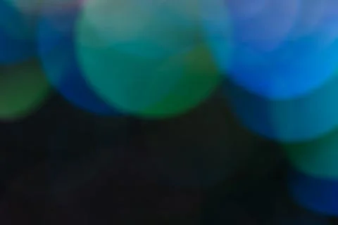 Abstract background of bright multi-layered bokeh on a dark background. Stock Photos