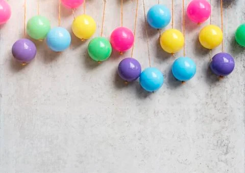 Abstract background from colorful balls hang on grey concrete wall. Party and Stock Photos