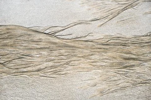 Abstract background created by the tide on the sand of a beach Stock Photos