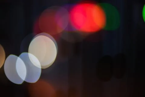 Abstract background featuring colorful glowing bokeh lights in dark night s.. Stock Photos