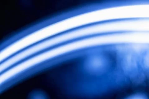 Abstract background featuring glowing line and soft, dark blue bokeh lights.. Stock Photos
