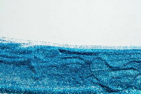 Abstract background featuring shiny blue glitter spread on a white surface .. Stock Photos