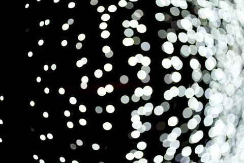 Abstract background of flickering lights with a side of unfocused white lights Stock Photos