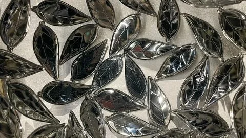 Abstract background of glossy reflective silver metal leaves creating a mod.. Stock Photos