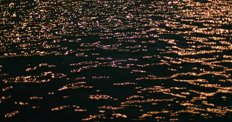 Abstract background golden light reflecting on rippling water surface at night Stock Footage 138135086