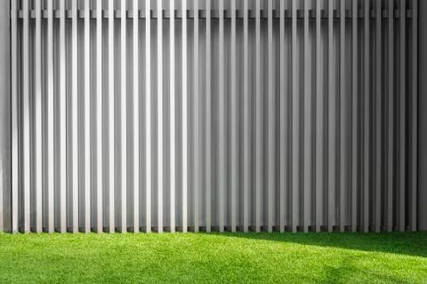 Abstract background from grey metal pattern wall with green grass floor. Stock Photos